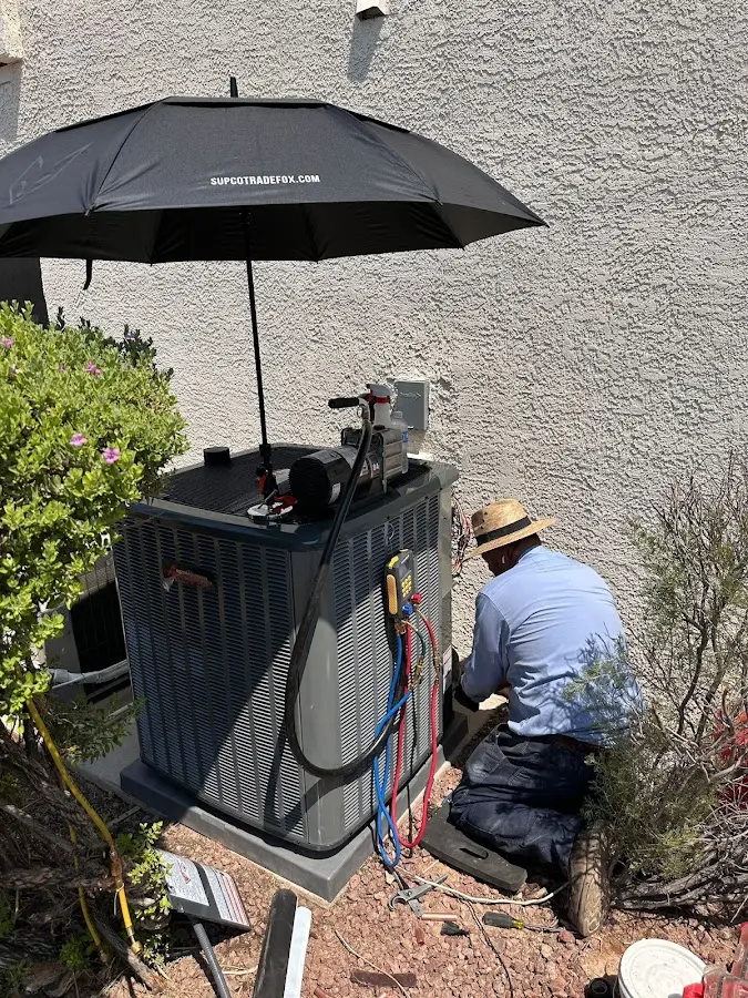 HVAC technician performing outdoor AC maintenance in Bear